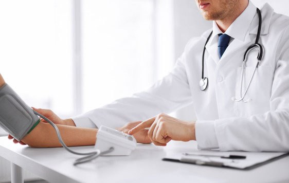 A doctor taking a patient&rsquo;s blood pressure