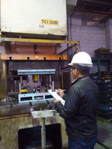 An engineer inspecting an industrial press